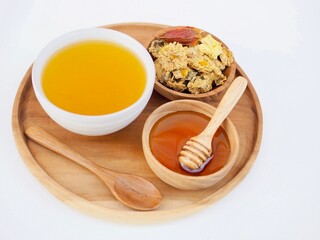Chrysanthemum tea is in a cup and honey is in a wooden cup. Healthy drinks.