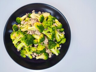 Stir-fried broccoli  with minced pork placed in a plate on white background. Healthy vegetable.