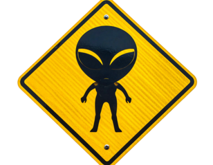A yellow diamond road sign displays an alien silhouette with large eyes. The sign has a textured, reflective surface