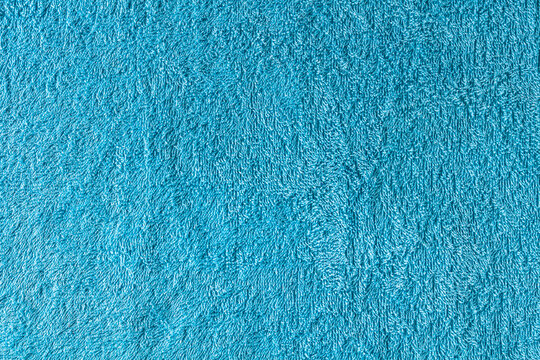 Close-up of blue towel, carpet, or rug texture. A plush and cozy background, perfect for themes related to comfort, home interiors, flooring, children spaces or any design themes.