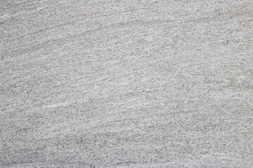 Light gray textured background that looks like fine-grained sand or subtle concrete finish. The...