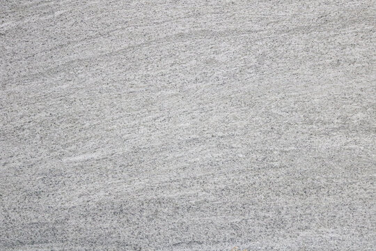 Light gray textured background that looks like fine-grained sand or subtle concrete finish. The surface has a minimalist aesthetic suitable for product photography, abstract designs, or as a backdrop.