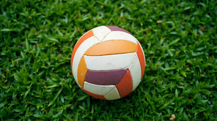 Vibrant volleyball resting on lush green grass, a symbol of outdoor sports and active play, summer