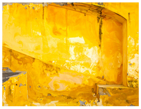 Abstract shot of vibrant, layered yellow paint on a rough, textured wall, showcasing a weathered architectural detail