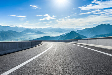 Empty asphalt highway road and beautiful mountain natural landscape under a blue sky with clouds