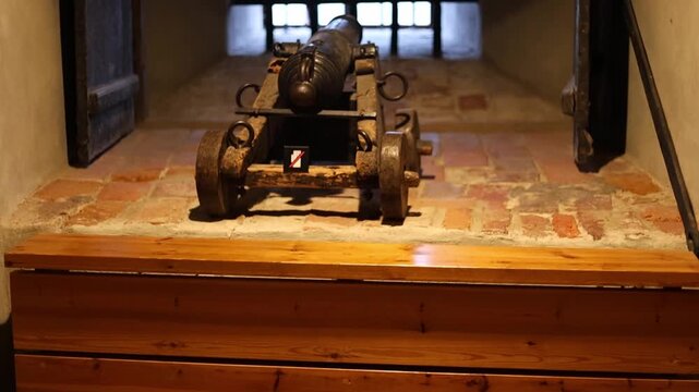 Dark stone prison inside a medieval castle, rusty bars, chains, and torch light illuminating the cold walls. Historical architecture and atmosphere of old confinement captured in 4K ultra HD.