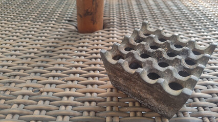 top view of metal ashtray on rattan woven table