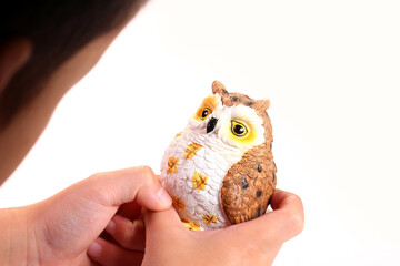 フクロウの置き物を持つ幼児の手
