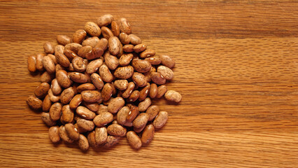small pile of dried pinto beans on a wooden cutting board