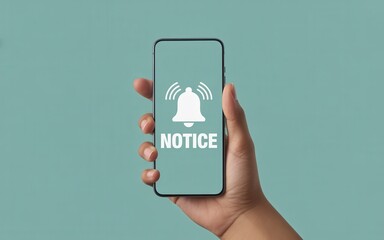 Hand holding smartphone displaying a notification alert with a bell icon and the word notice
