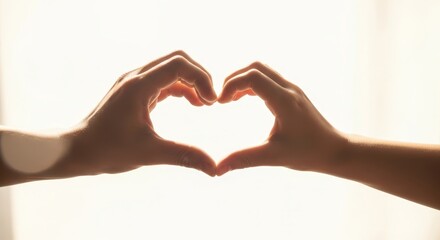 Obraz premium Silhouette of Hands Forming Heart Shape Against a Bright Background
