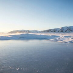 Fototapeta premium Pristine Arctic Winter Scene: Golden Light on Blowing Snow, Frozen Lake, and Majestic Snow-Capped Mountains