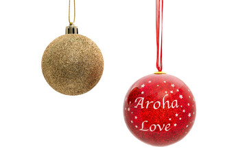 Two beautiful Christmas baubles seen against a plain white background. On one decoration is written Aroha which is the Maori word for Love.