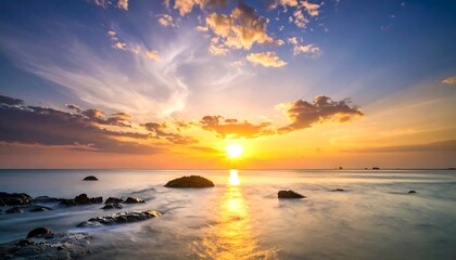 Vibrant Ocean Sunset with Reflective Waters and Silhouetted Rocks.