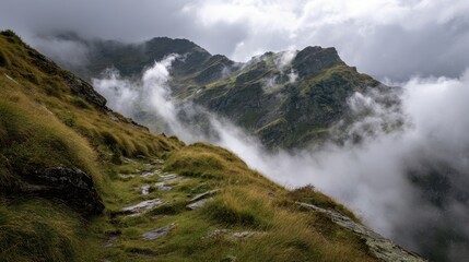 Winding stone path along a grassy mountain ridge enveloped in dramatic clouds and mist.