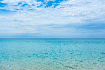 Fototapeta premium Nature of the ocean and blue sky Summer with sunshine, sandy beaches, clear blue waters sparkling against the blue sky. on an island with good ecology and environment Background for summer vacation