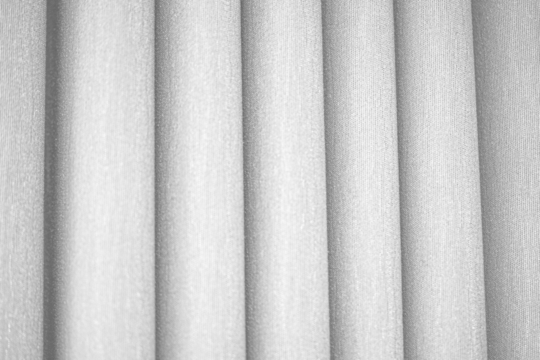 Textured gray curtains in elegant folds showcased on a mockup overlay, highlighting the beauty of gray fabric for fabric shops and design elements.