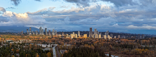 Fototapeta premium Urban Skyline Of Burnaby Across Autumn Forests Under Cloudy Sky In Greater Vancouver Canada