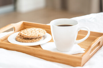 Tray with coffee and crackers breakfast on a bed
