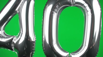 Shiny silver foil balloons forming the number 40 floating against a vibrant green screen background perfect for chroma key compositing in birthday anniversary or milestone celebration videos.