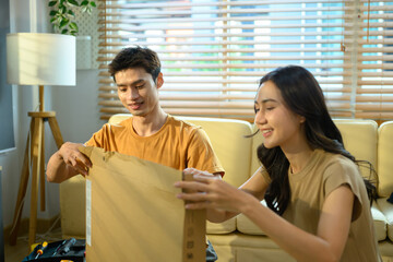 Happy couple unbox a new furniture at home