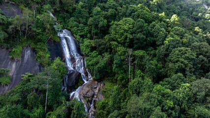 Aerial view of waterfall surrounded by lush jungle and rocks, Waterfall and forest green tree, Waterfall in deep jungle with forest tree.