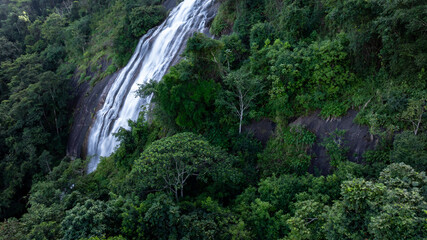 Aerial view of waterfall surrounded by lush jungle and rocks, Waterfall and forest green tree, Waterfall in deep jungle with forest tree.