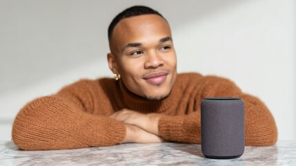 A focused individual gazes thoughtfully at a sleek smart speaker. The image highlights his focused intent.