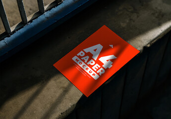 Square Paper or Flyer Mockup on a Dark Surface with Dramatic Shadow and Light