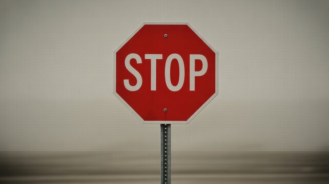 Classic red octagonal stop sign with white text on a pole. 
