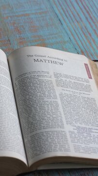 The book of Matthew of the new testament, Holy Bible. Printed form, the New Revised Standard Version. High angle, vertical video.