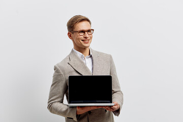 smiling young caucasian man hold laptop wear glasses suit stand isolated on white background...
