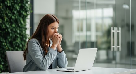Focused Professional Woman Contemplating Project Strategy with Laptop in Modern Office Setting Repre.jpg