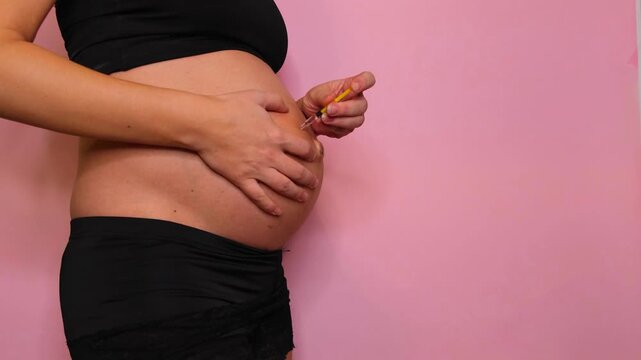Woman injecting medicine into her pregnant belly. Gestational diabetes treatment and health care during pregnancy. Medical concept.