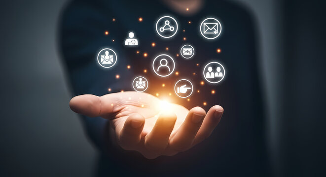 A person's outstretched hand holds glowing digital icons representing communication, networking, and social connections, symbolizing technology.