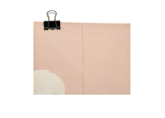 Torn pastel beige paper sheet with black binder clip isolated on white background, ripped textured craft paper for notes, messages, invitations, scrapbooking, stationery design