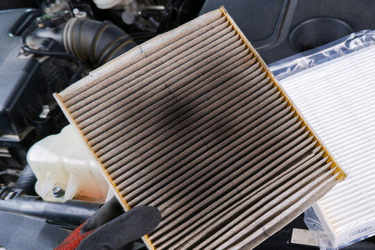 Old, clogged air filter removed from air system. Essential auto maintenance for engine performance and cabin air quality.