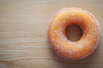 Top View of Sugared Cruller Donut Ring on Light Wooden Surface