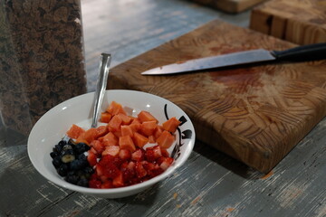 Bowl of Fresh Fruit with Knife and Cutting Board