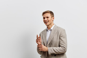 Friendly smiling man in beige blazer and white shirt standing against plain white background. Business casual appearance carefree cheerful confident confident man portrait. People lifestyle concept