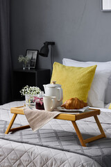 Sophisticated rural breakfast setup against calm gray linens in bedroom