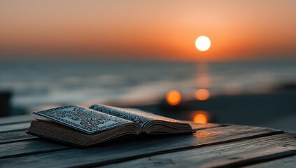 An open book rests on a weathered wooden table overlooking a serene sunset over a calm ocean.  Warm, golden light bathes the scene
