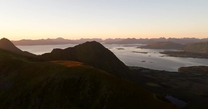 Aerial drone view from Storheia mountain at sunset, overlooking sea and surrounding mountains, Stokmarknes, Norway
