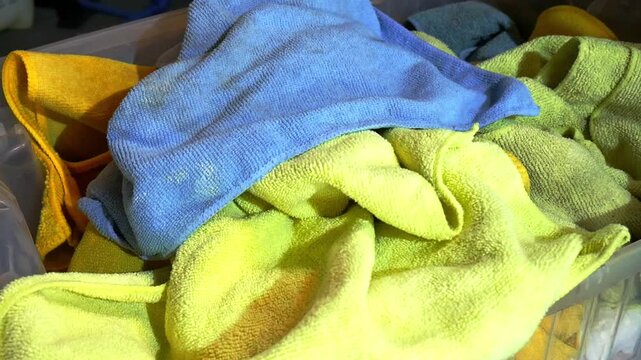 Close up throwing dirty micrfiber towels into laundry basket