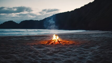 Cozy beach campfire at dusk with gentle waves and silhouetted hills in background creating peaceful atmosphere for relaxation and reflection