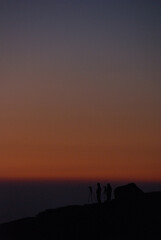Silhouettes of photographers waiting to see the sunrise on the mountaintop in the early morning, and a sunrise scene (hyper zoom shot) / 早朝の山頂で御来光の瞬間を待つカメラマンたちのシルエットと朝焼けシーン(冬の朝，超望遠ズーム撮影)