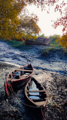two wooden boats resting on low tide mudflat in the evening.