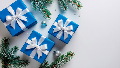 Three blue gift boxes with white ribbons and pine branches on a white background, symbolizing Christmas or holidays.