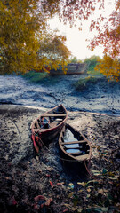 two wooden boats resting on low tide mudflat in the evening.