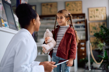 Happy little girl talking to a pharmacist in a pharmacy.